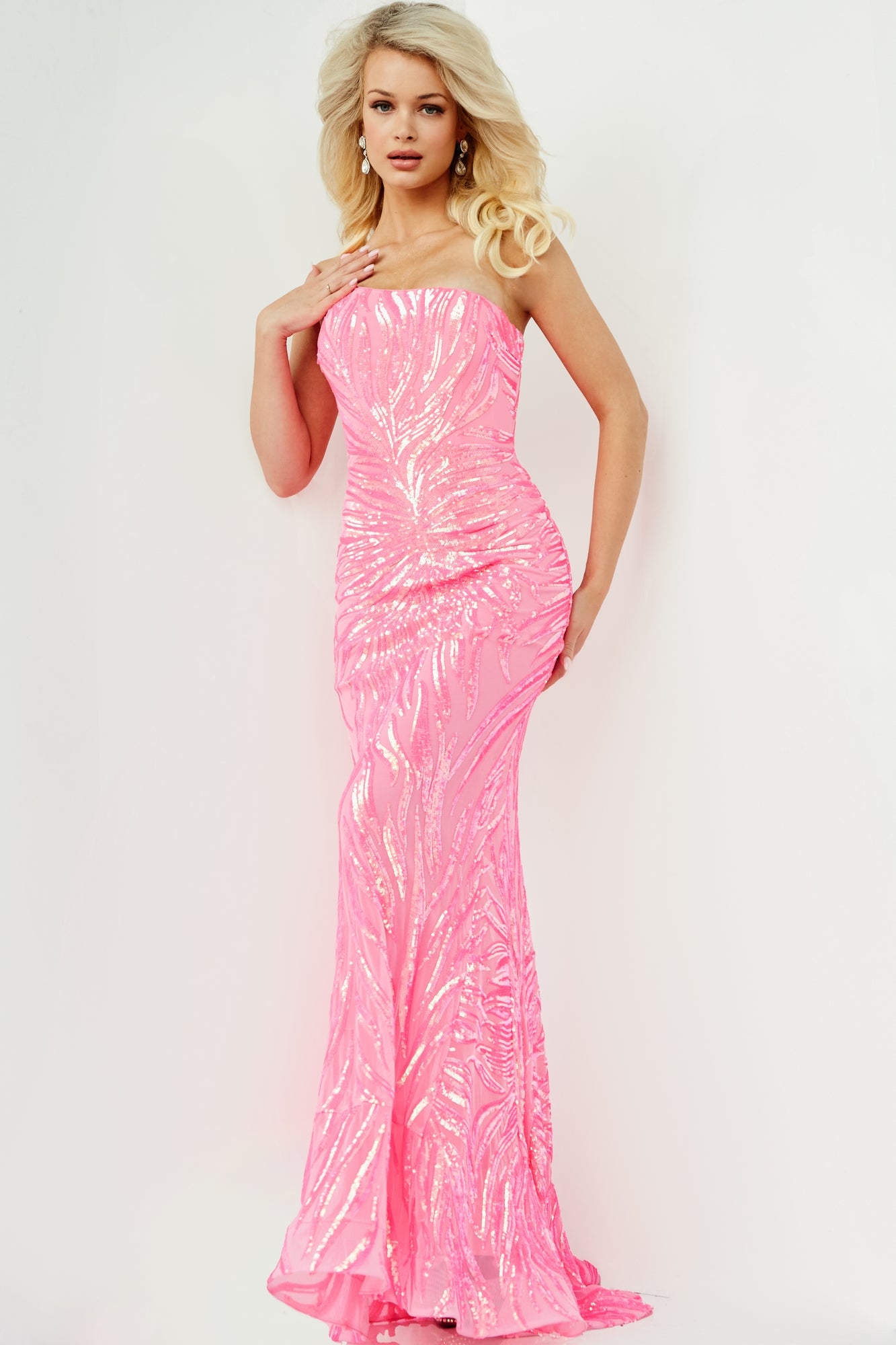 A woman wears the Jovani One-Shoulder Long Sequin-Print Prom Dress, a fitted, floor-length pink gown, standing against a plain white background.